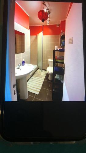 een badkamer met een witte wastafel en een toilet bij La petite maison du 93 in Bagnolet