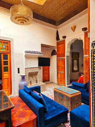 a living room with blue couches and a fireplace at Dar Bryan in Fès