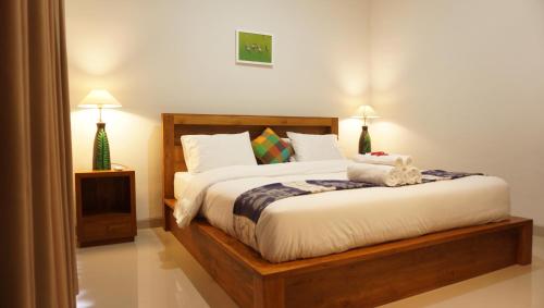 a bedroom with a bed with white sheets and pillows at Griya Alit Guest House in Ketewel
