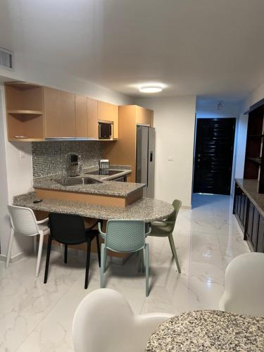 a kitchen with a table and chairs and a refrigerator at Edificio Solarium in Porlamar