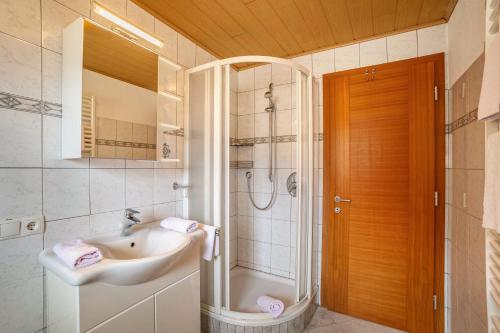 uma casa de banho com um lavatório e um chuveiro em Gartnerhof Apt Glücksklee em Fleres