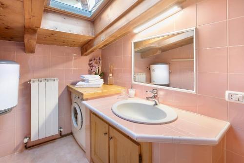 a bathroom with a sink and a washing machine at Casa Colturi Abete in Valdisotto