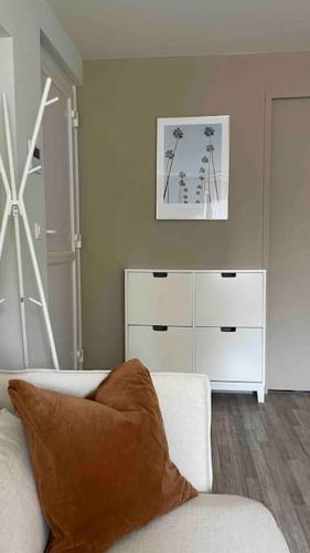 - un salon avec un canapé et une commode dans l'établissement Charmant petit 2p 10min Disney, à Guermantes