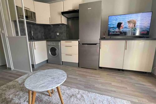 Cette chambre dispose d'une cuisine avec une télévision et une table. dans l'établissement Charmant petit 2p 10min Disney, à Guermantes