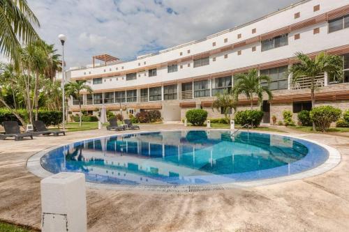 a large swimming pool in front of a building at Apartamento Cleo in Cancún