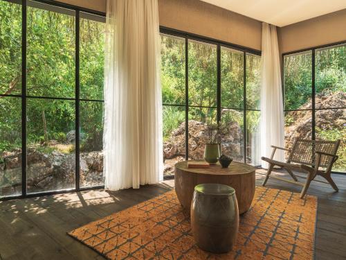 a living room with large windows and a table at Yazz Collective in Fethiye