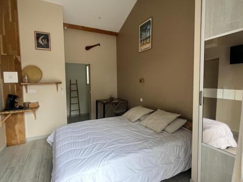 1 dormitorio con 1 cama blanca grande. en Gîte du Pin avec Spa privatif, en Pey
