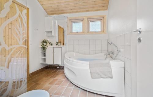 a white bathroom with a tub and a sink at Beautiful Home In Sjllands Odde With Wifi in Tjørneholm
