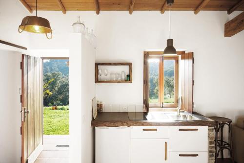 una cocina con armarios blancos y una ventana en MOBA - Monte do Barranquinho, en São Luis