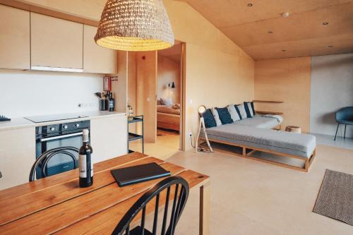 a kitchen and living room with a table and a couch at MOBA - Monte do Barranquinho in São Luis