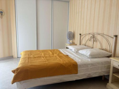 - une chambre avec un lit doté d'une couverture en or dans l'établissement Appartement 2P à Juan les Pins : emplacement idéal, parking, terrasses, proche plage et commerces - FR-1-252-188, à Antibes