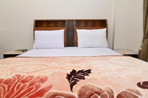 een slaapkamer met een groot bed met witte lakens bij وادى الملوك للشقق الفندقية in Mansoura