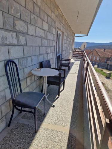 a row of chairs and a table on a balcony at Apartman Vujovic in Zlatište