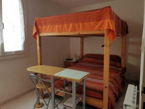 een slaapkamer met een stapelbed, een tafel en een bureau bij Appartement Saint-Hilaire-de-Riez, 3 pièces, 4 personnes - FR-1-324A-49 in Saint-Hilaire-de-Riez