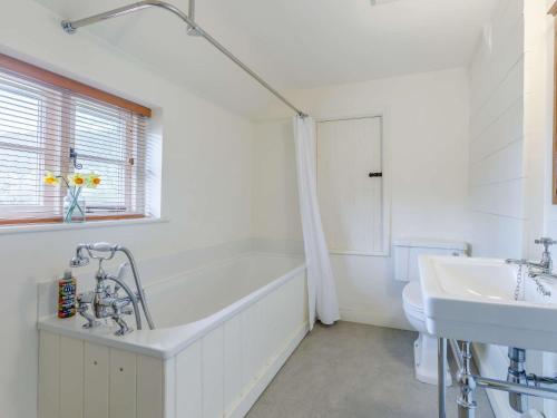 a white bathroom with a tub and a sink at 2 Bed in Dulverton 47152 in East Anstey