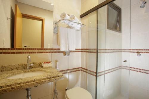 y baño con aseo, lavabo y ducha. en Castelo Inn Hotel, en Goiânia