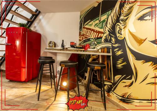 un bar avec des tabourets et un tableau sur le mur dans l'établissement LOFT 