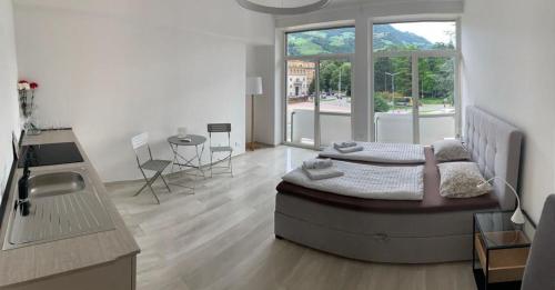 1 dormitorio con cama y ventana grande en Alps Apartments Viktory, en Bolzano