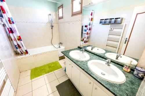 een badkamer met 2 wastafels en een grote spiegel bij Sun and comfort near the park in Les Angles Gard