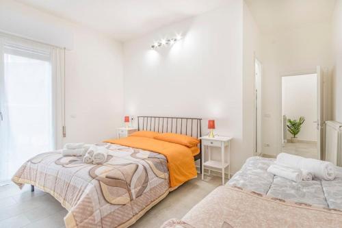 ein weißes Schlafzimmer mit 2 Betten und einem Tisch in der Unterkunft Mutina Design Suite - City life & Hesperia Hospital in Modena
