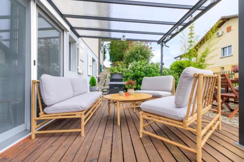 a patio with two chairs and a table on a deck at Bohème - Home cinéma, Terrasse, Parking & Proche Lac in Estavayer-le-Lac