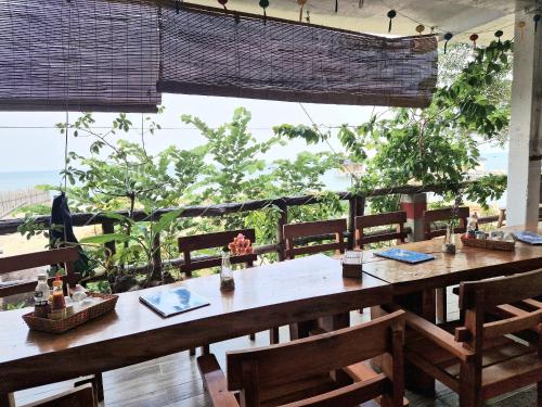 jadalnia ze stołami i krzesłami oraz dużym oknem w obiekcie Butterfly Rose Beach Resort Phú Quốc Francophone w Duong Dong