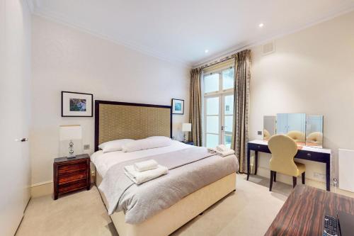 - une chambre avec un lit, un bureau et une table dans l'établissement Stunning 2BD flat in South Kensington with a patio, à Londres