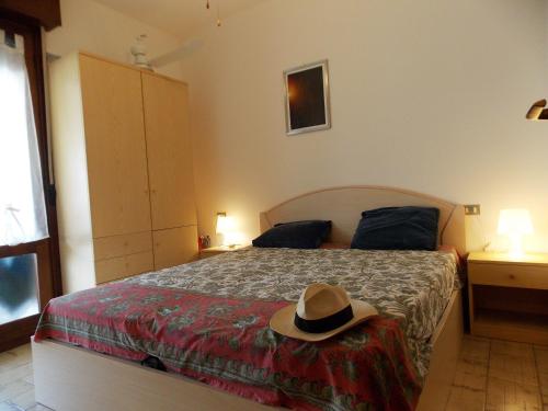 um quarto com uma cama com um chapéu em CONDOMINIO ATHENA em Bibione