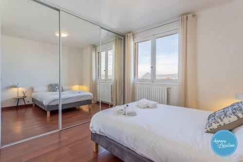 a bedroom with two beds and a large window at L'Éclat D'annecy - Appartement Avec Vue Lac in Annecy