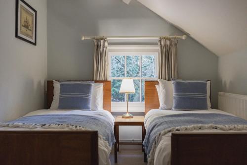 2 camas en una habitación con ventana en Bears Cottage, en Wood Norton