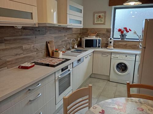 une cuisine avec un évier et un lave-vaisselle dans l'établissement Charmant Gîte Familial à Saint-Benoît-sur-Loire - 2 Chambres, Parking, Proche Patrimoine et Nature - FR-1-590-426, à Saint-Benoît-sur-Loire