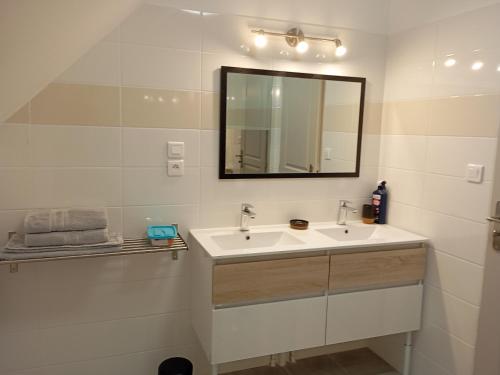 a white bathroom with a sink and a mirror at Gîte Saint-Benoît-sur-Loire, 3 pièces, 6 personnes - FR-1-590-426 in Saint-Benoît-sur-Loire