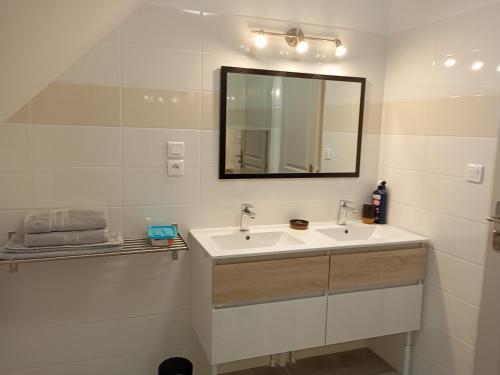 a white bathroom with a sink and a mirror at Charmant Gîte Familial à Saint-Benoît-sur-Loire - 2 Chambres, Parking, Proche Patrimoine et Nature - FR-1-590-426 in Saint-Benoît-sur-Loire