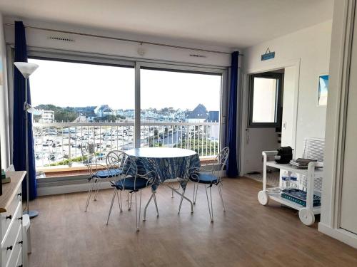 une pièce avec une table et des chaises et une grande fenêtre dans l'établissement Studio calme avec balcon ensoleillé, proche plage - FR-1-392-228, au Pouliguen