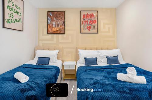 2 camas en una habitación con sábanas azules y blancas en Stylish City Centre Escape, Serviced Accommodation in Birmingham Suitable For Families, Visitors & Contractors, Wi-Fi, Games & Netflix - By Noor Luxury Accommodations, en Birmingham