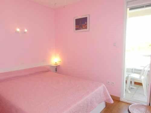 - une chambre rose avec un lit et une fenêtre dans l'établissement Appartement 2P proche plage, parking, Quartier Grande Plage - FR-1-782-9, au Barcarès