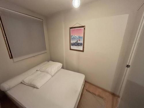 Cette petite chambre dispose d'un lit avec une photo murale. dans l'établissement Appartement 2 pièces au calme avec terrasse aux Angles - FR-1-593-110, aux Angles