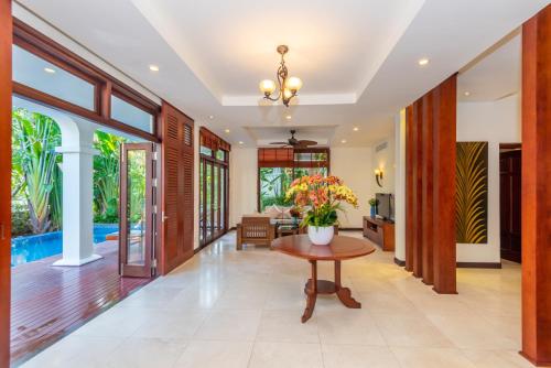 a hallway with a table and a living room at Abogo Champa Villa Beach Da Nang in Da Nang