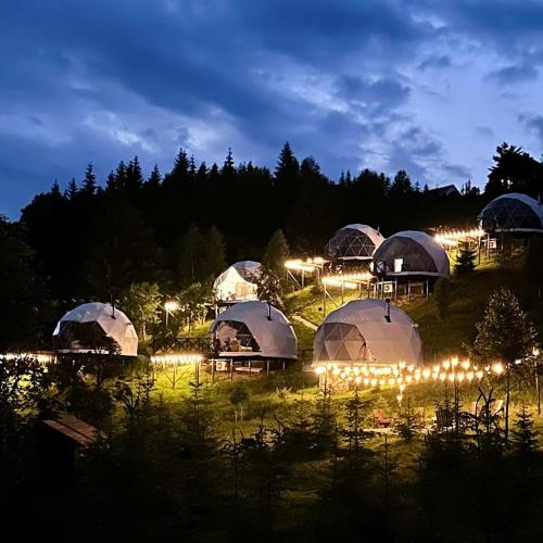 a group of domes with lights in a field at night at Charlton Estate in Yablunytsya