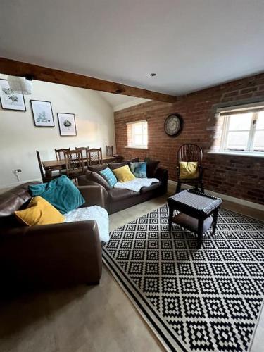 - un salon avec des canapés et un mur en briques dans l'établissement Grand Mill: Near to Shops, Attractions, Restaurant, à Burton-on-Trent