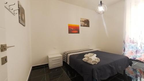 um pequeno quarto com uma cama com um lençol preto em Tra centro e mare - Intero appartamento con parcheggio em Savona