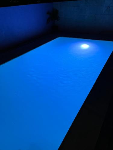 - une piscine baignée de lumière bleue dans une pièce sombre dans l'établissement SanAndros Airbnb, à Marsh Harbour