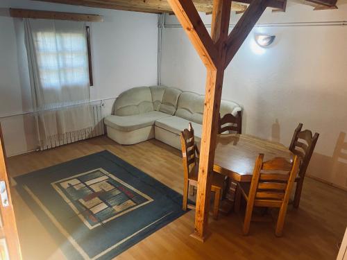 een woonkamer met een tafel en een bank bij Veress Apartman Tusnádfürdő in Băile Tuşnad