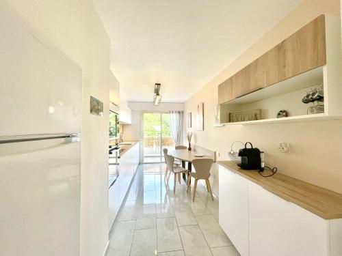 - une cuisine et une salle à manger avec des placards blancs et une table dans l'établissement Vezelay 3 luxury 3 bedrooms, by Welcome to Cannes, à Cannes