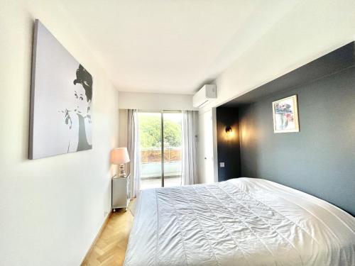 une chambre avec un lit blanc et une fenêtre dans l'établissement Vezelay 3 luxury 3 bedrooms, by Welcome to Cannes, à Cannes