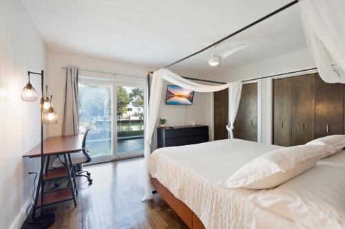 a bedroom with a bed and a desk and a window at Waterfront - Kayak & Paddleboards - Firepit - Pool in Miami