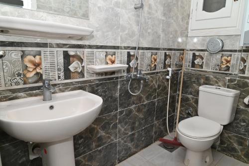 een badkamer met een wastafel en een toilet bij وادى الملوك للشقق الفندقية in Mansoura