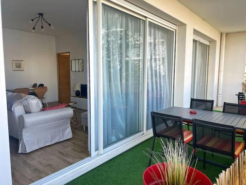 d'un salon avec une grande porte coulissante en verre. dans l'établissement Le Surcouf - Terrasse privative, à La Rochelle