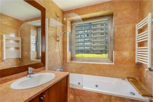 a bathroom with a sink and a tub and a window at Luxury Living by the Sea Matosinhos Marvel in Matosinhos