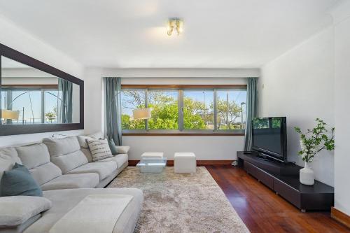 a living room with a couch and a tv at Luxury Living by the Sea Matosinhos Marvel in Matosinhos